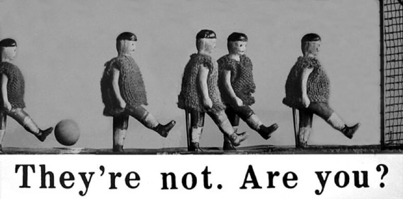 Five toy football players with a ball and the caption: They're not. Are you?